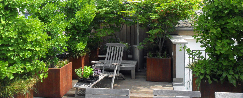 Beispiel 3 von Dachbegrünung eines Dachgartens: ein Sitzplatz auf der Dachterrasse wird durch Elemente aus Corten-Stahl, Gehölzen vor Wind und Einblicken geschützt.