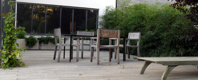 ErhÃ¶hte Holzterrasse aus Ipe-Holz in einem Privatgaten. Im Mittelpunkt Gartenmöbel aus Holz. 